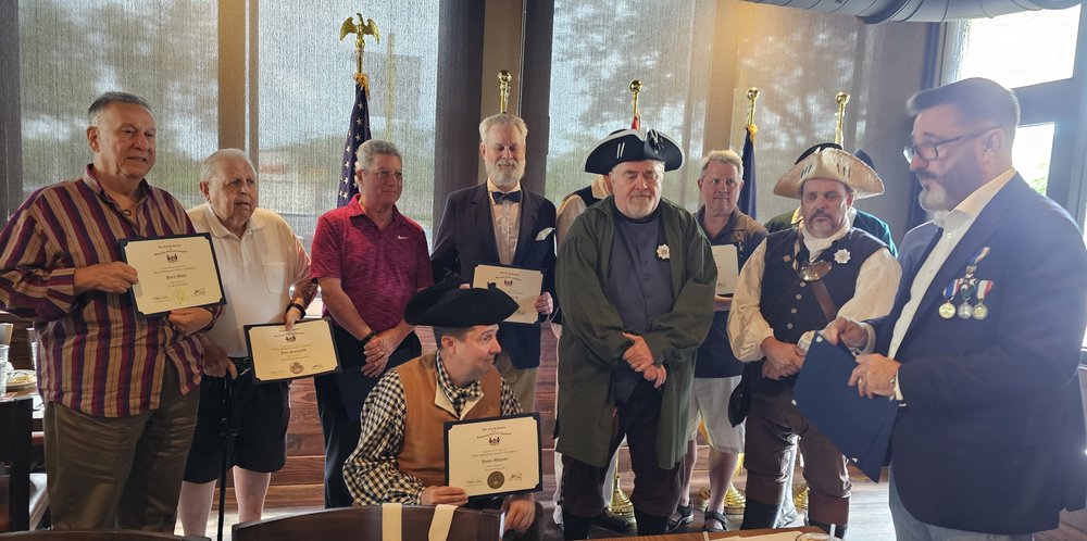 FAAM Chair presenting FAAM Fellow and Minuteman certificates to Fort Lauderdale Compatriots. Back row (left to right): Barry Moss, John Sauerwald, Pete Stevenson, Samuel Frankel Jr., Tom Carpenter, Herb Gardner, Mark Snider, FAAM Chair. Front: Jason Milgram