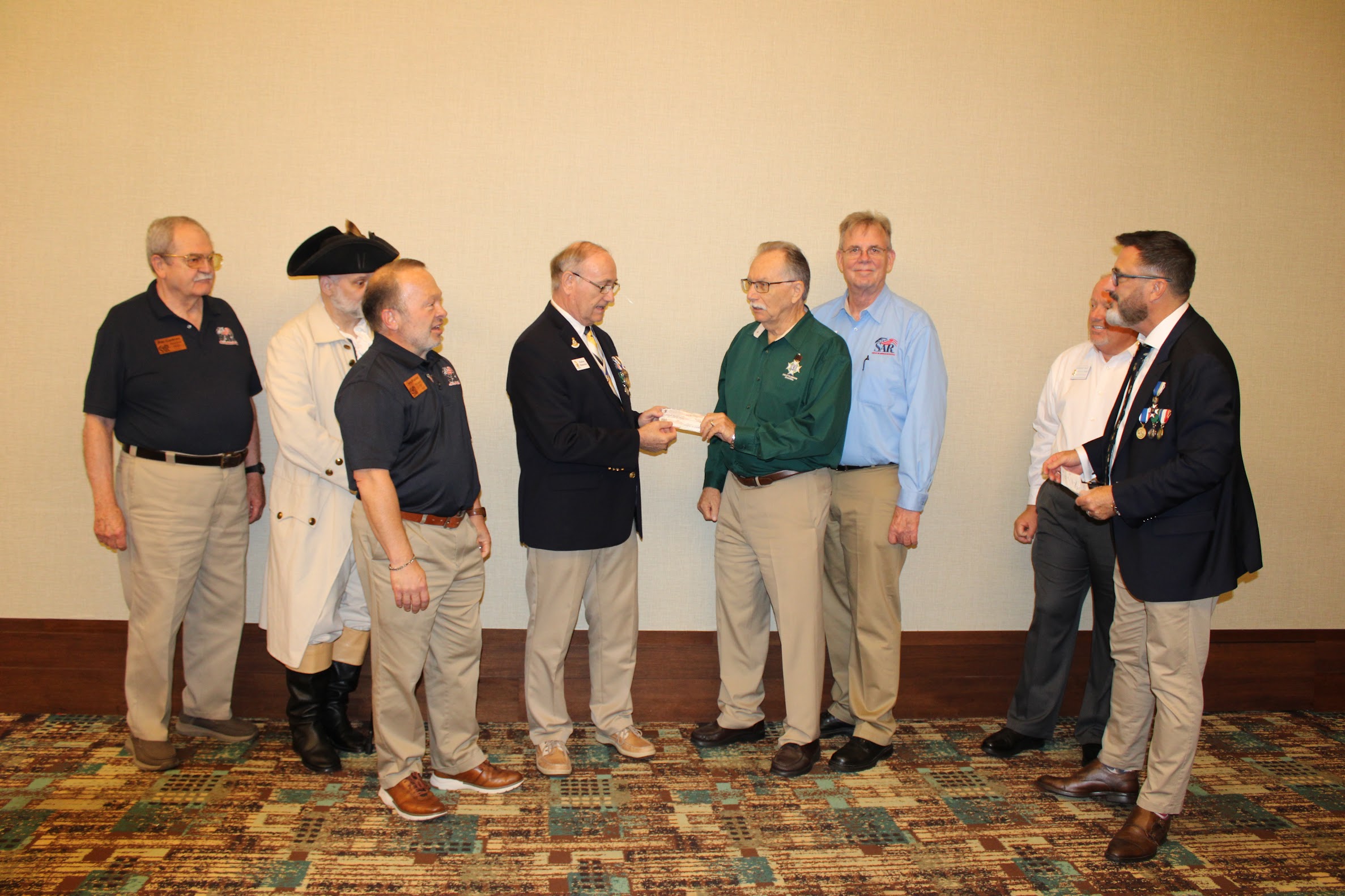 FAAM Secretary Robbie Robinson accepting an additional donation from Earl Mathews at the 2025 Fall Board of Management meeting