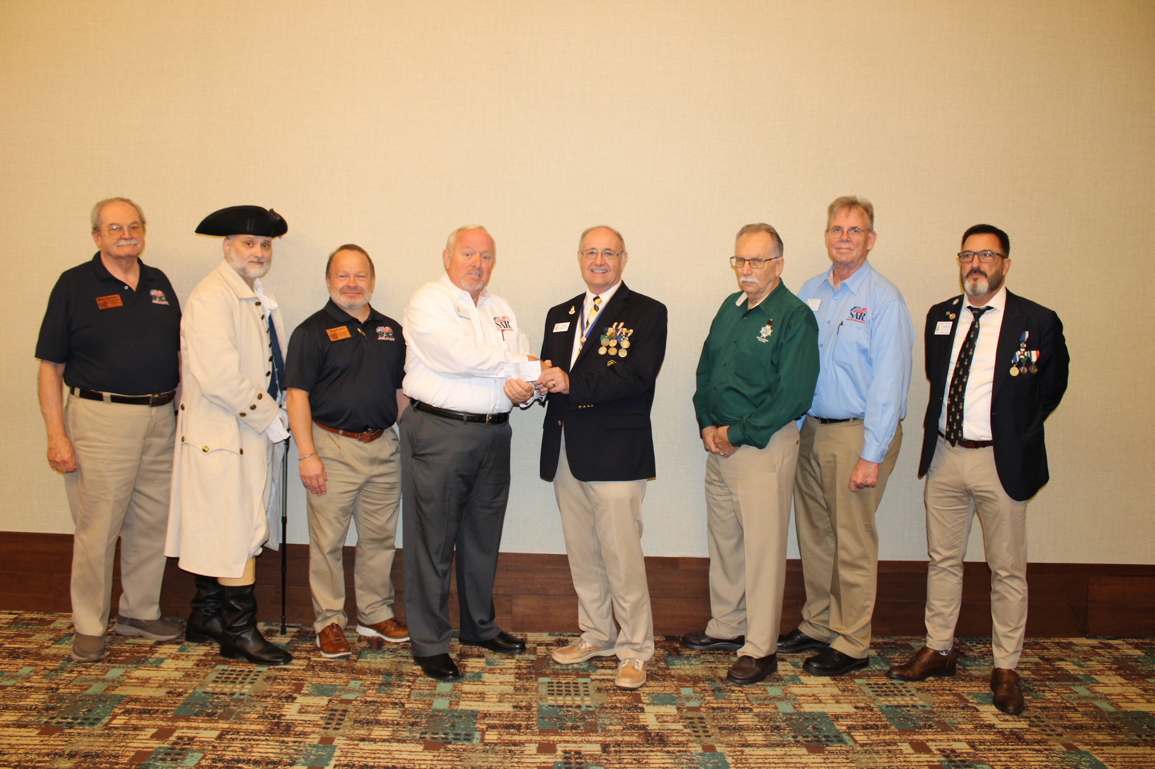 FAAM Secretary Robbie Robinson accepts a $1,000 donation from FLSSAR Senior Vice President Jonathan Hunt at the 2025 Fall Board of Management meeting