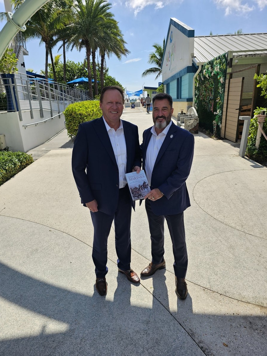 Barron Fuller, President of Harrah's-Caesars (left), receives complimentary copy of 'Washington's Marines' from SAR FAAM Chair (right)